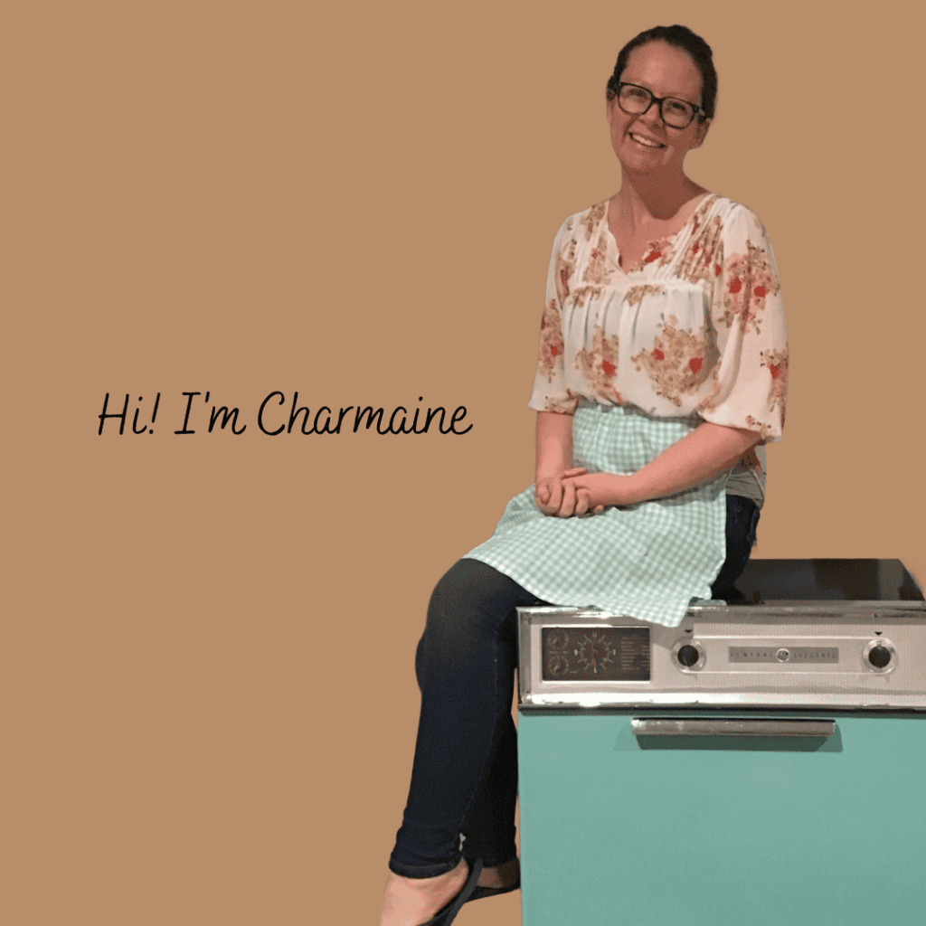 Charmaine in her apron sitting on an oven, ready to cook for new moms!